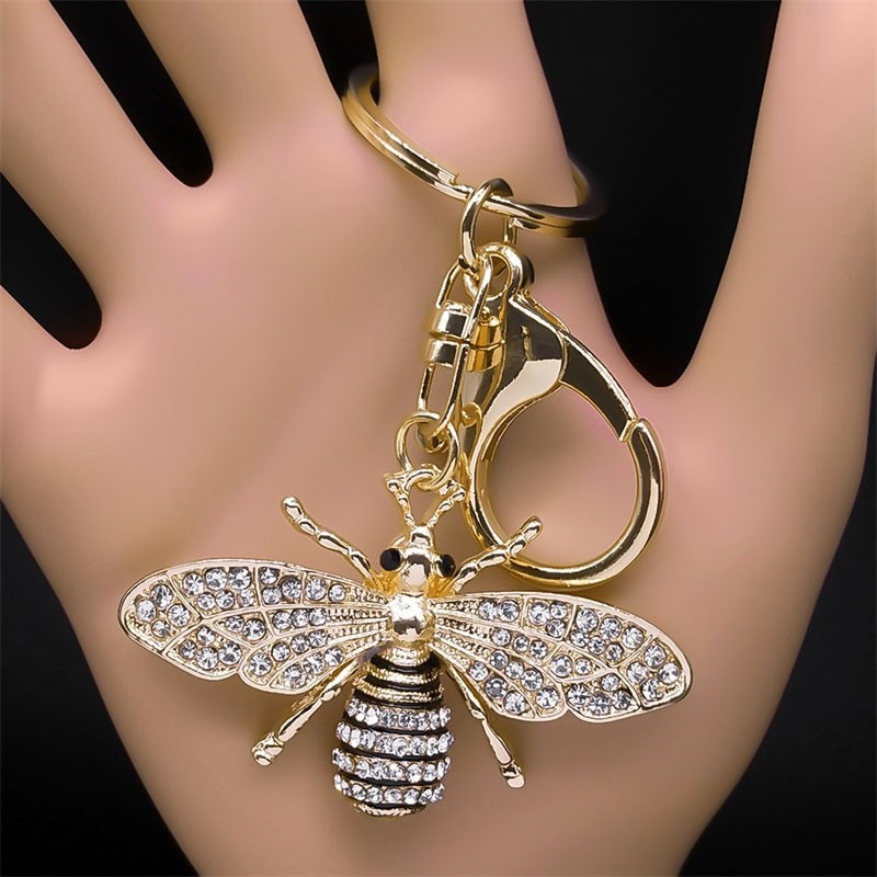 Chaveiro dourado com uma abelha de cristal